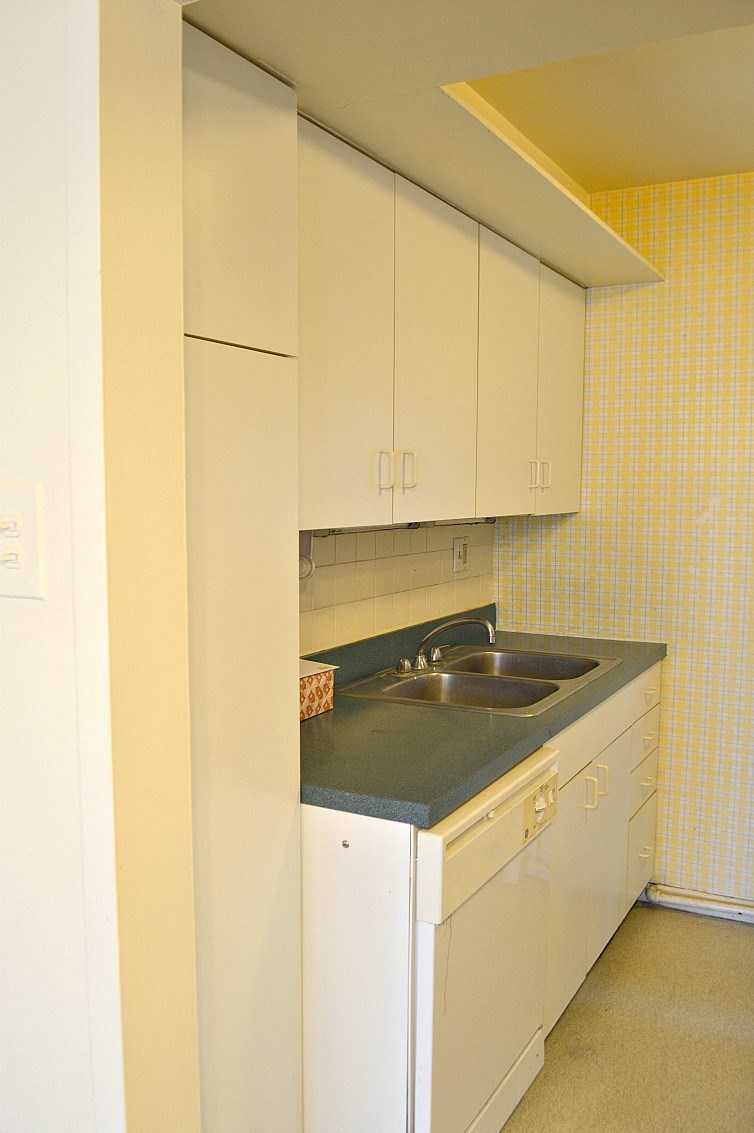 a small kitchen with white cabinets and a sink