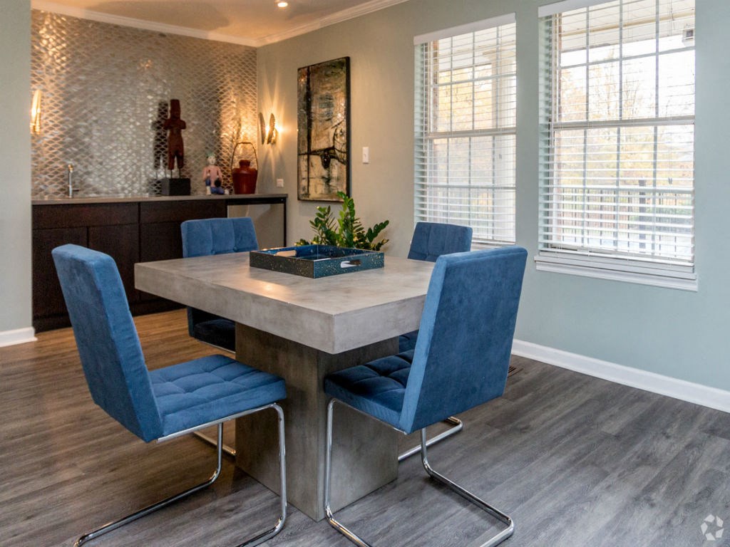 a dining room with a marble table and blue chairs