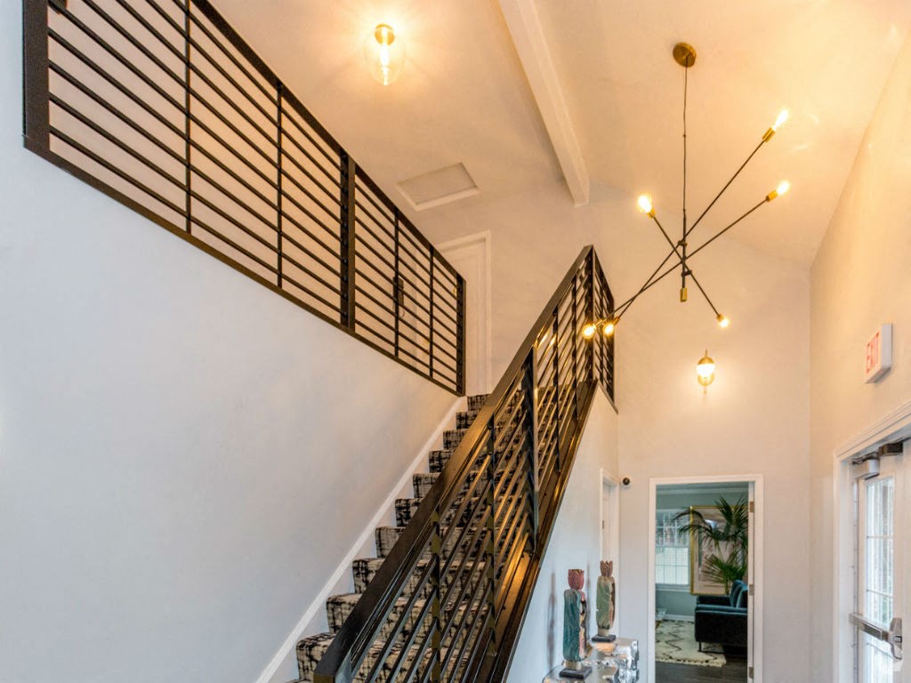 the staircase in the center of the house with wrought iron railings