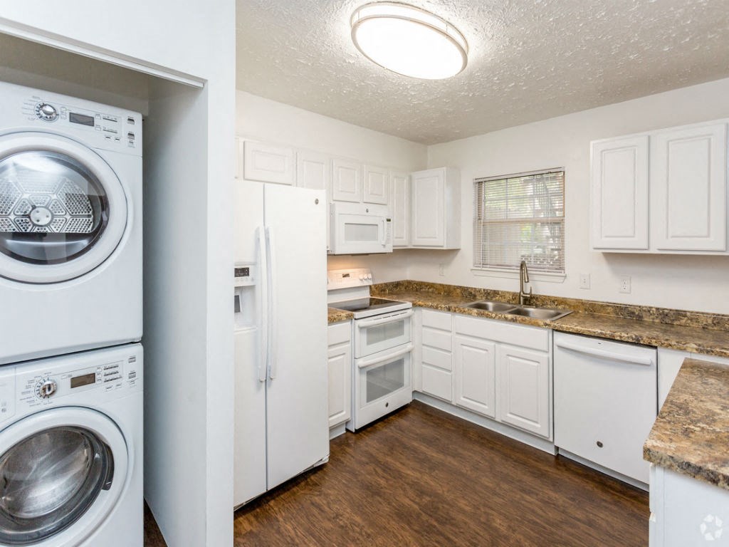 a white kitchen with a washing machine and a sink