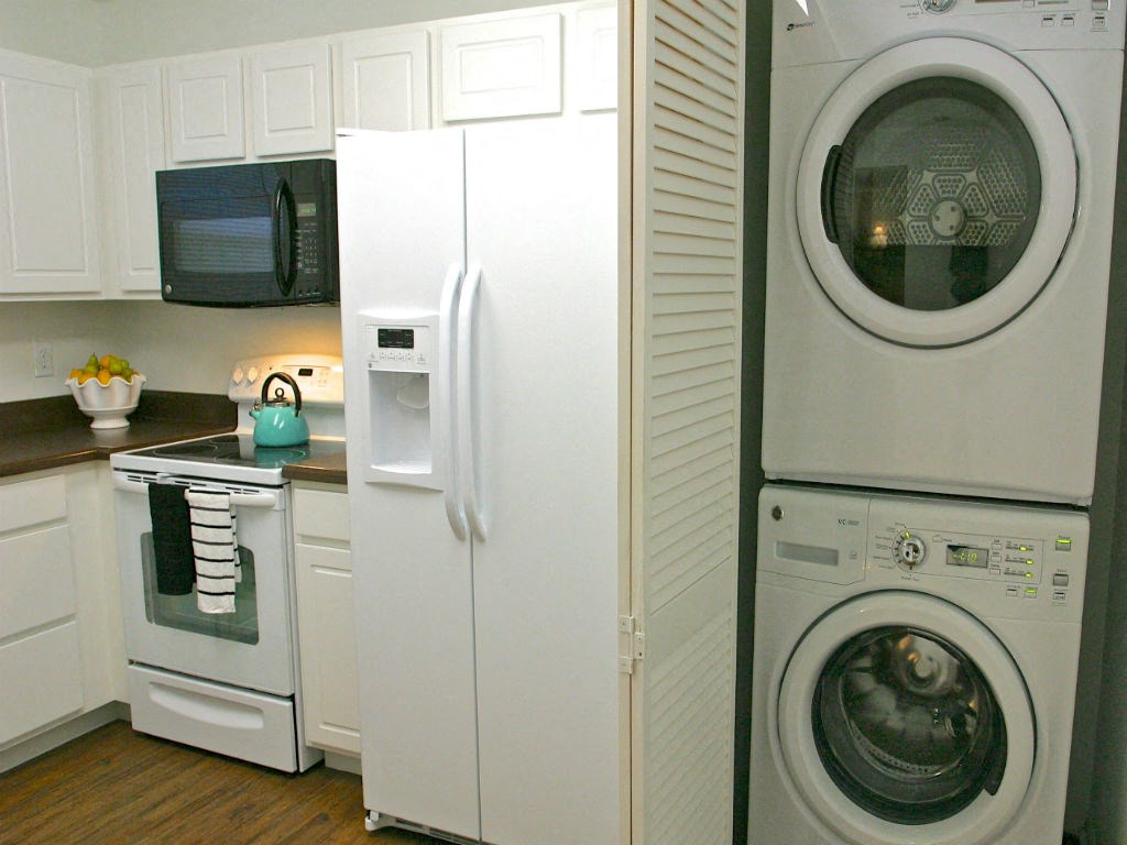 a white kitchen with a washing machine and a refrigerator
