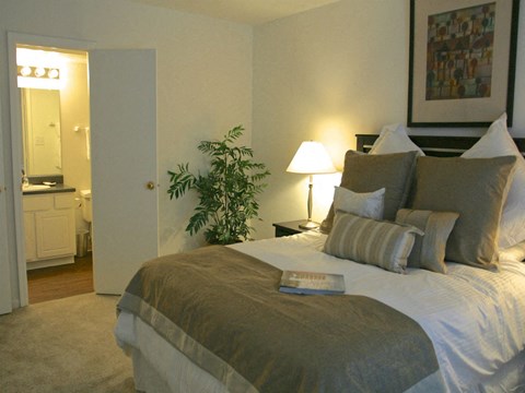 a bedroom with a bed and a bathroom with a sink