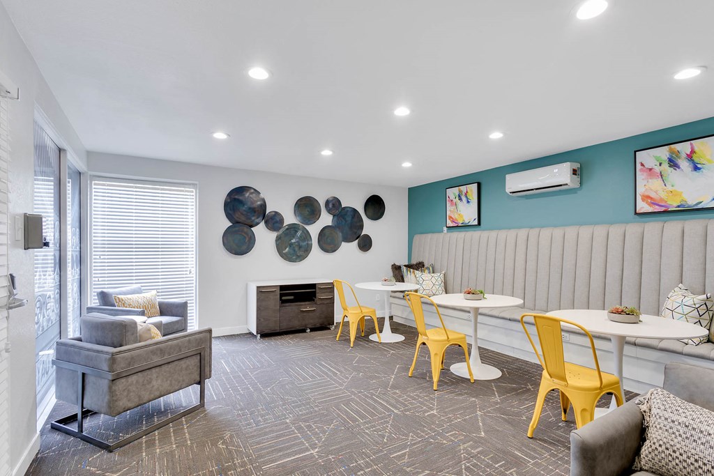 a living room with yellow chairs and a table