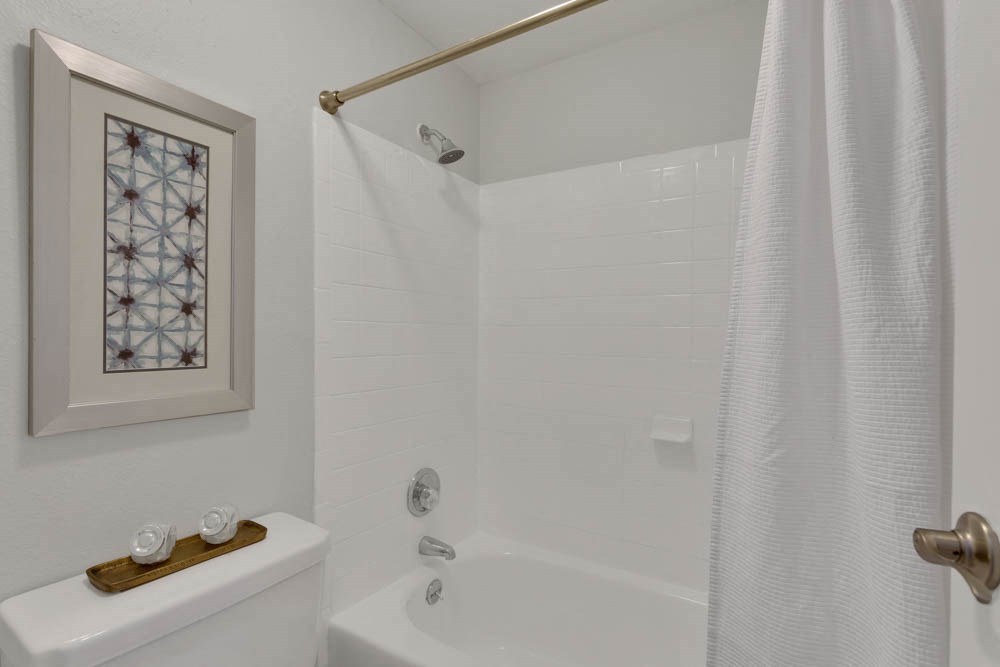 a white bathroom with a shower and a sink