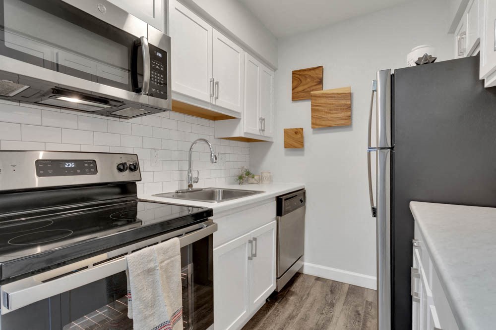 a kitchen with stainless steel appliances and white cabinets