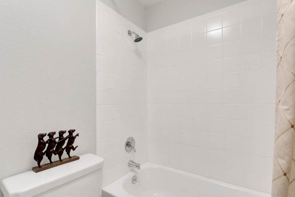 a white bathroom with a tub and a toilet and a sink