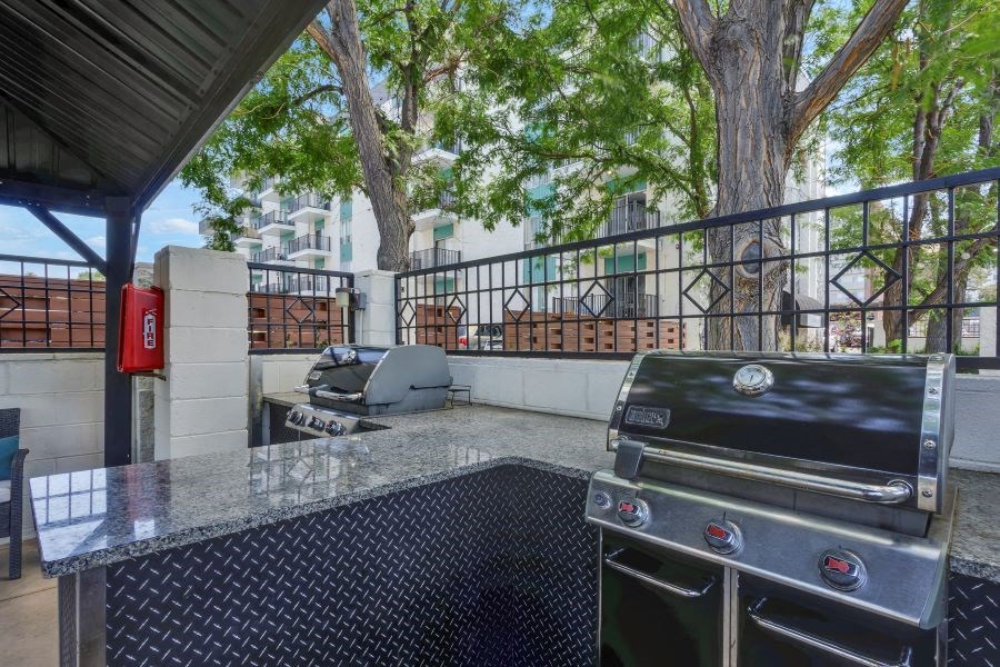a patio with a grill and a table