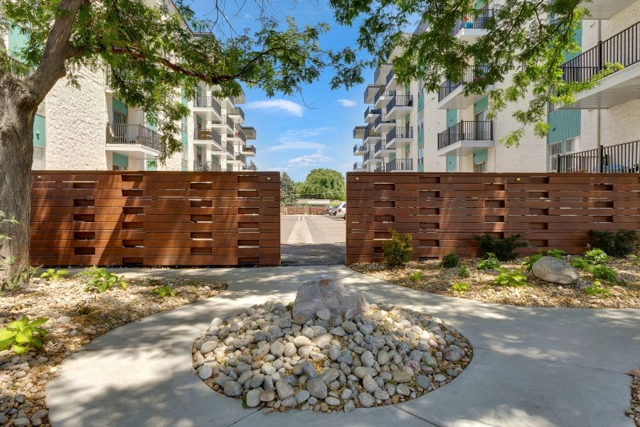 a stone circle in front of a wooden fence with an apartment building