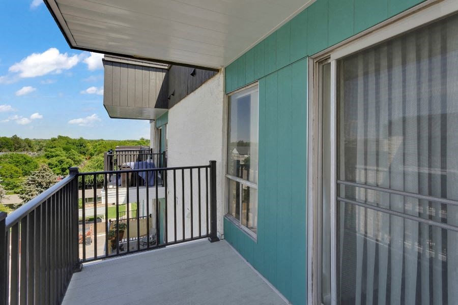 a balcony with a view of a yard and a building