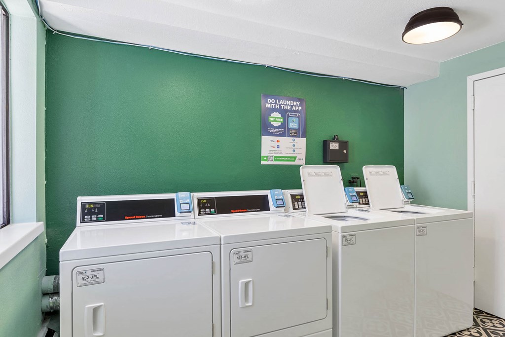 a laundry room with two washers and two washing machines