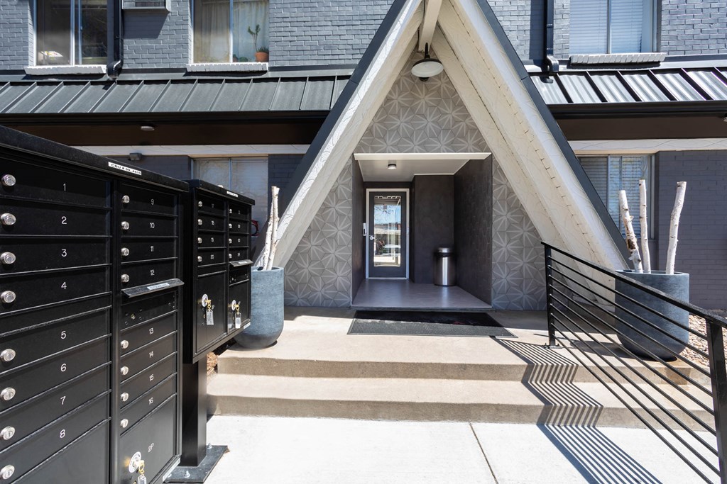 the front entrance to a house with stairs and a black door
