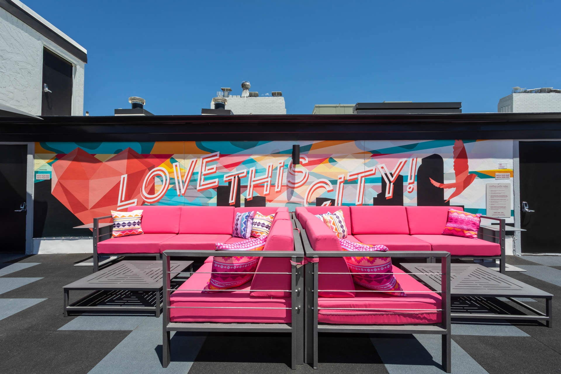 a pair of pink couches in front of a wall with graffiti