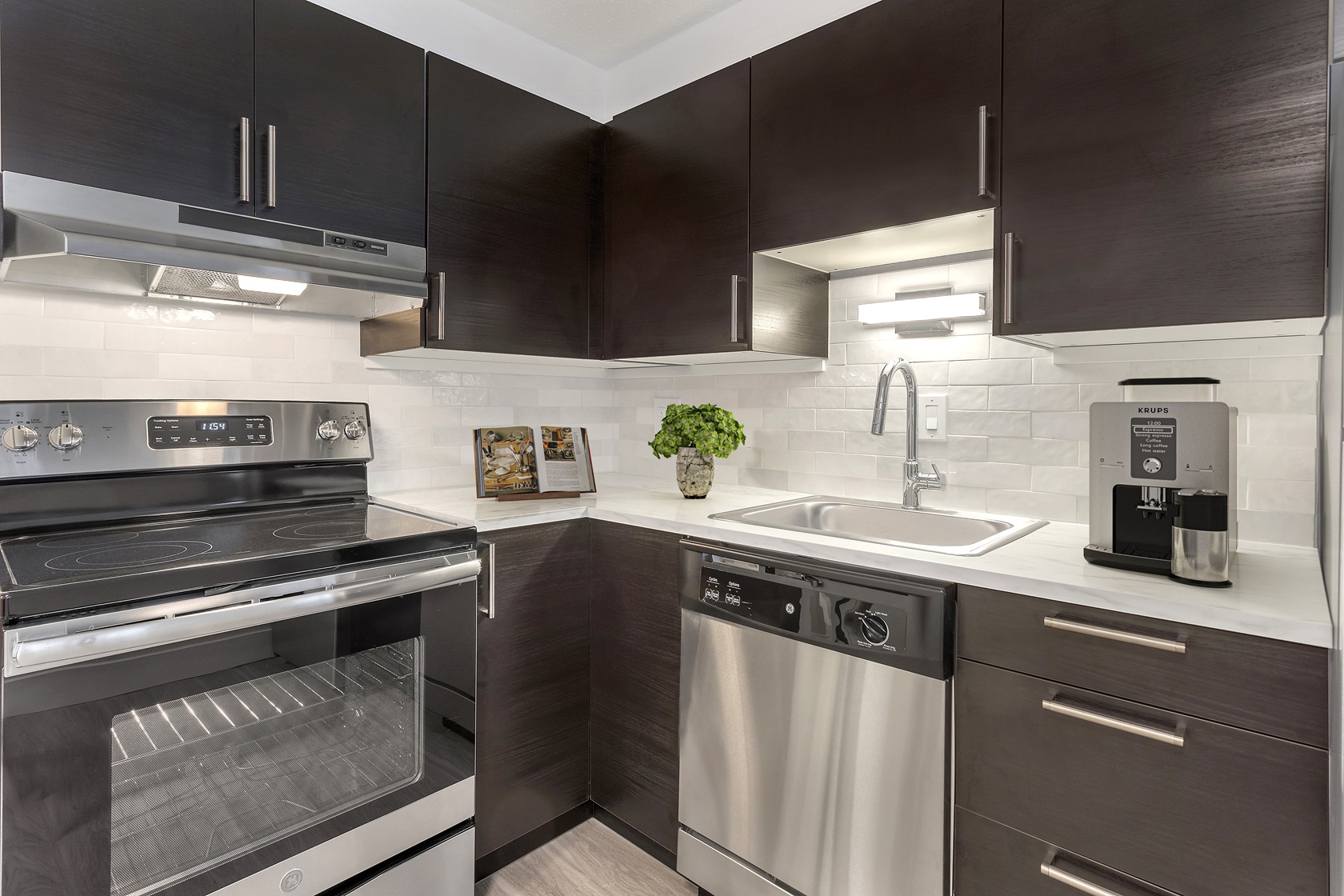 A modern kitchen with dark brown cabinets and stainless steel appliances.