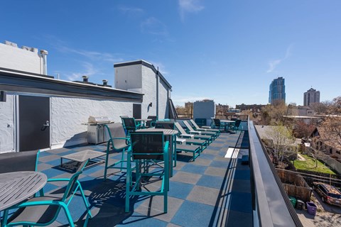 a roof deck with tables and chairs on top of a building