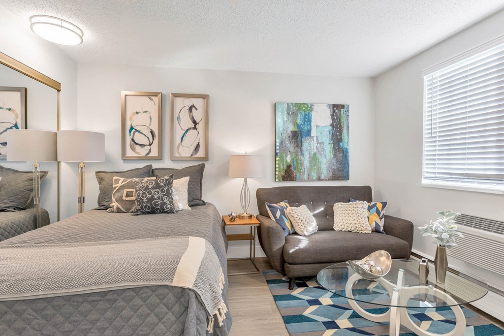 a bedroom with a bed and a chair and a table