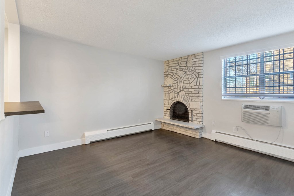 an empty living room with a fireplace and a window