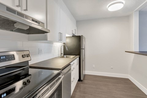 a modern kitchen with stainless steel appliances and white cabinets