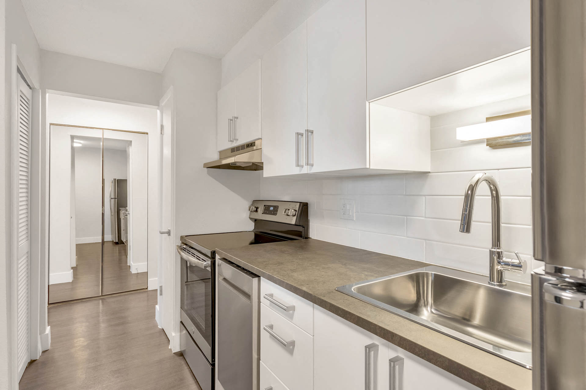 a kitchen with stainless steel appliances and white cabinets