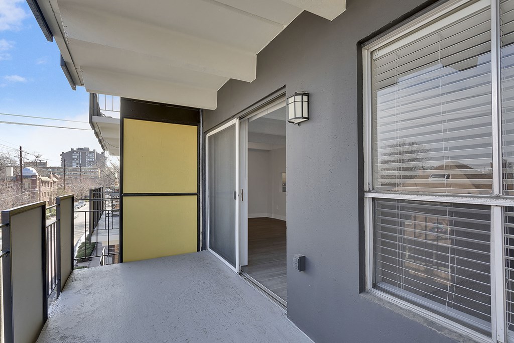 a balcony with a door and a view of the city