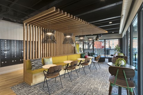 a lounge area with tables and chairs and a wooden structure