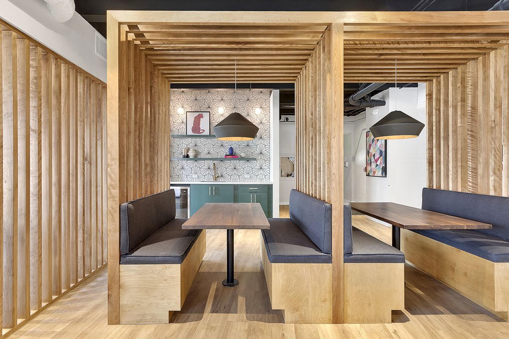 a dining area with tables and chairs and a wall with wood dividers
