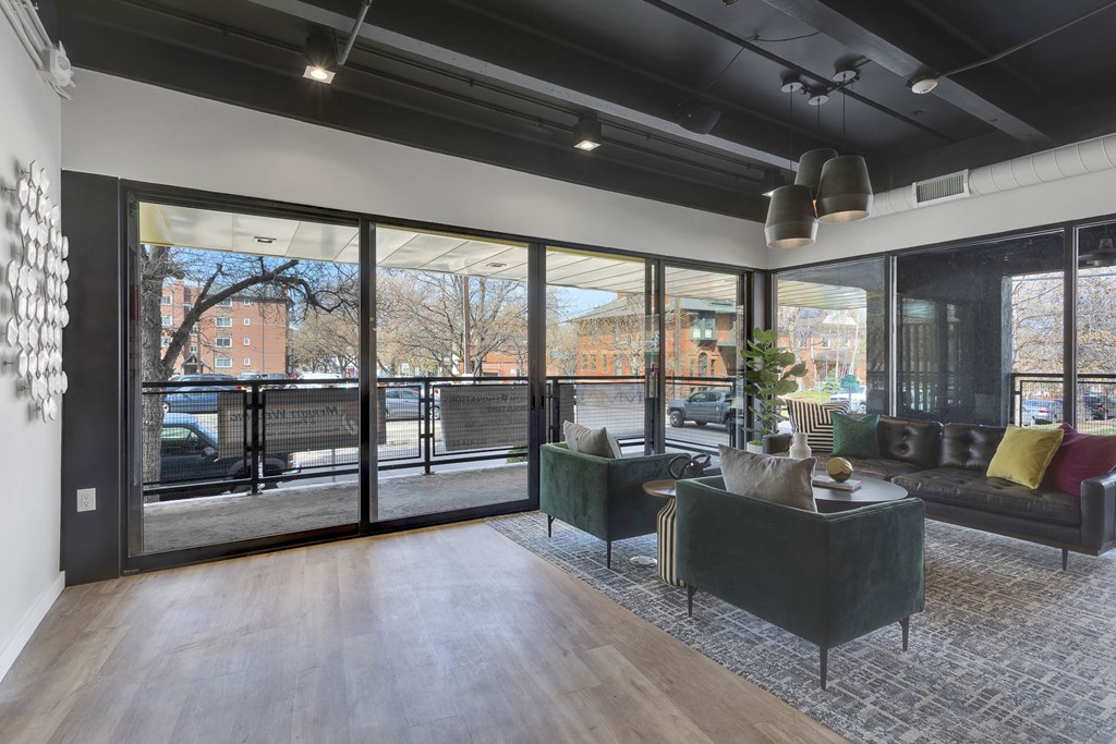 a living room with couches and chairs and large windows