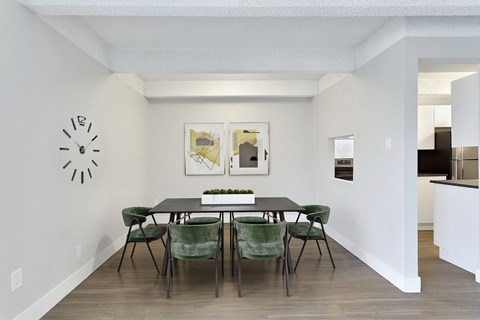 a dining room with a table and chairs and a clock on the wall
