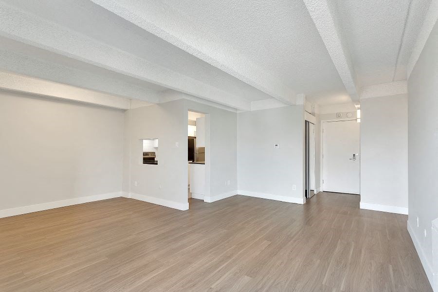 an empty living room with white walls and wood floors