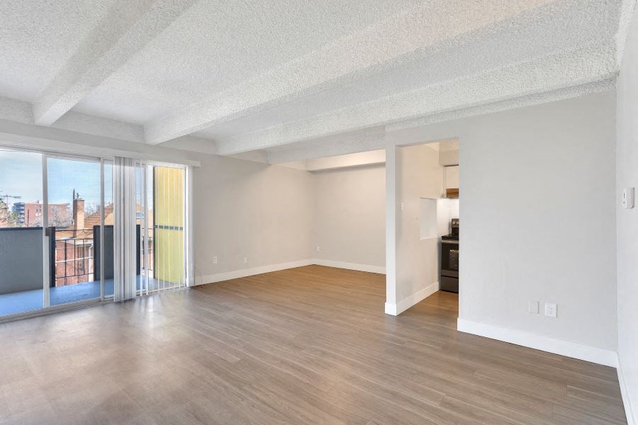 an empty living room with wood floors and a balcony