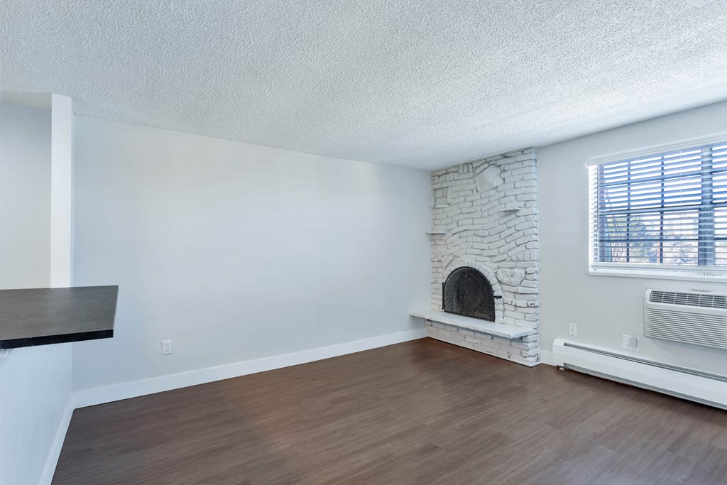 a living room with a stone fireplace and a window