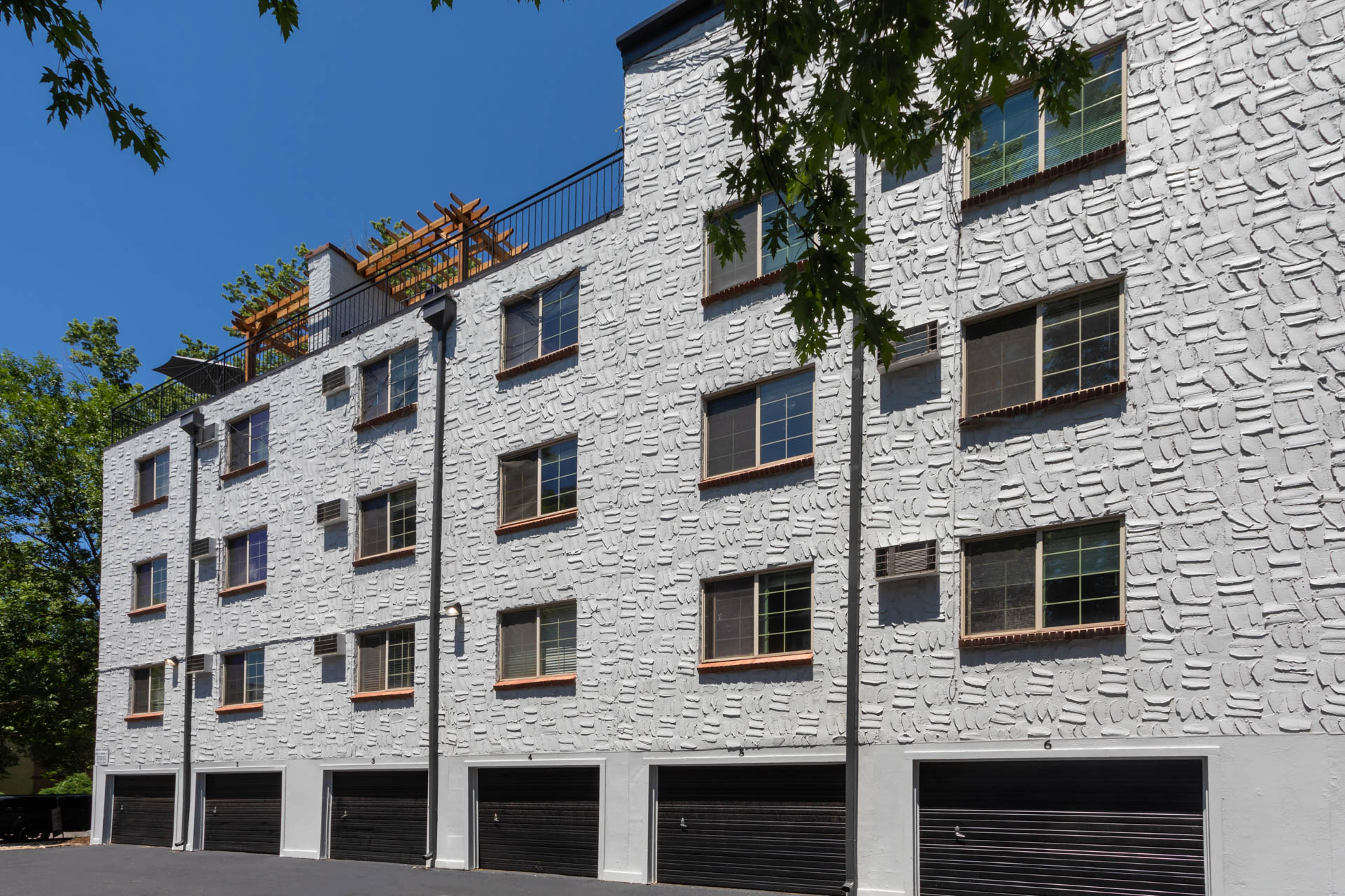 a white brick building with a row of garage doors