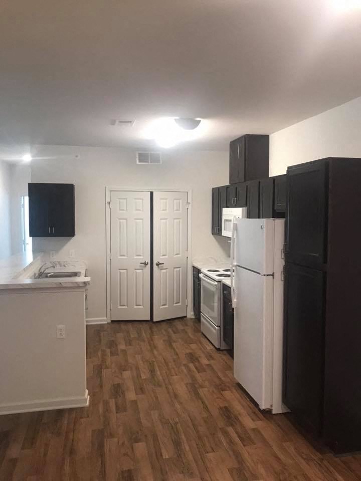 a kitchen with a refrigerator and a stove and a door
