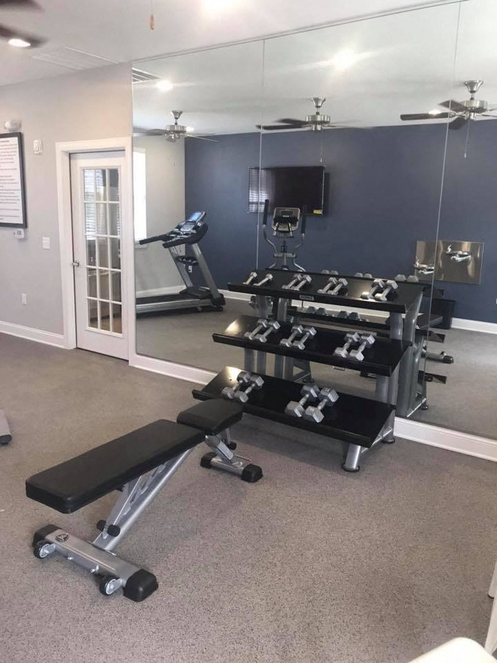 a home gym with weights and a mirror on the wall