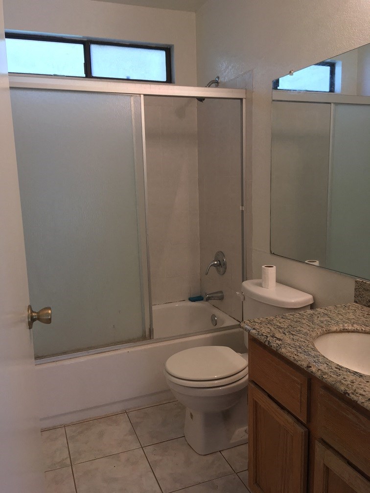 a bathroom with a shower and a toilet and a sink