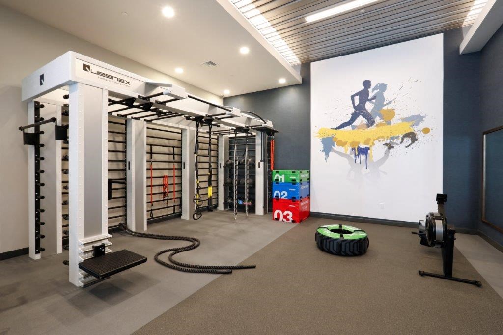 Fitness gym featuring weights and an artistic painting on the wall