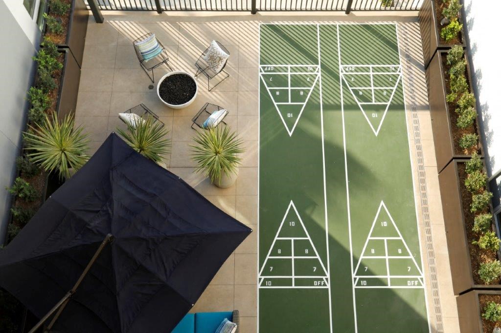 A cozy fire pit surrounded by seating and a shuffleboard court, offering a fun and inviting outdoor space.