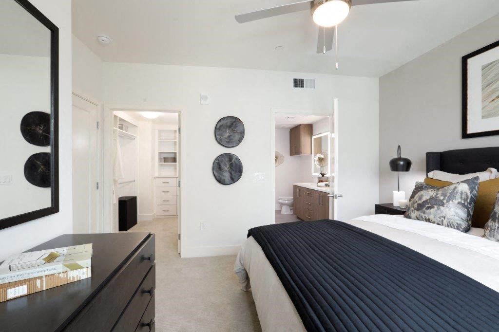 Bedroom with a dresser and bathroom visible