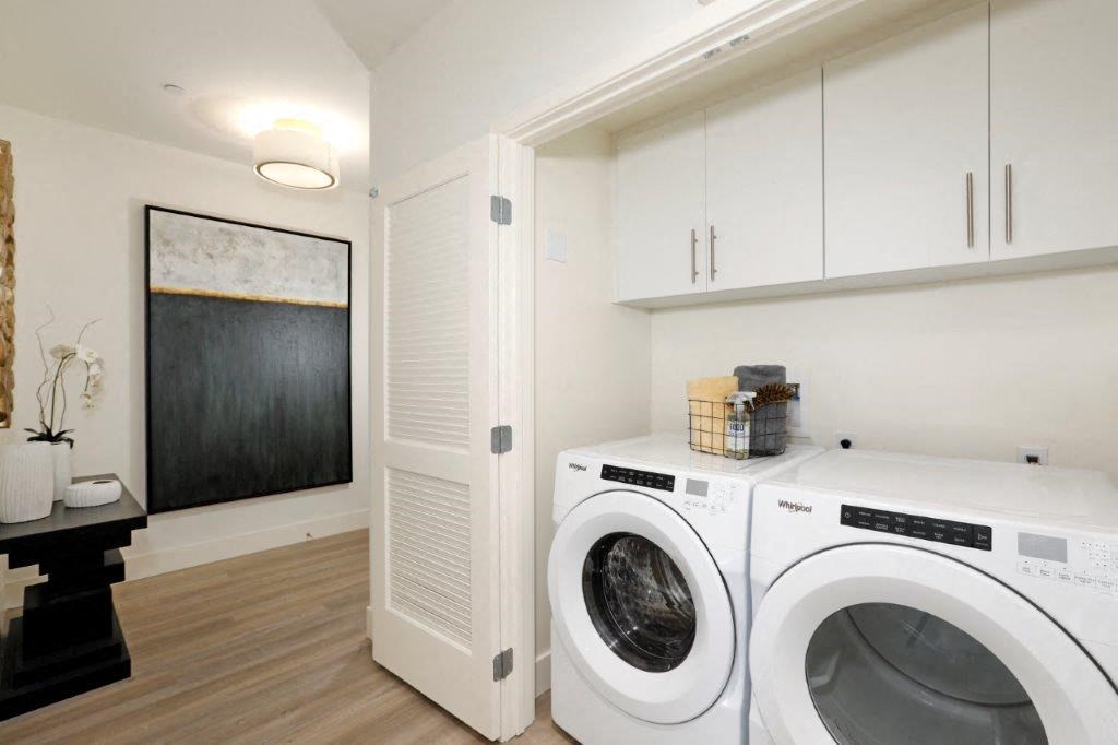 Laundry room with washer, dryer, and white cabinets