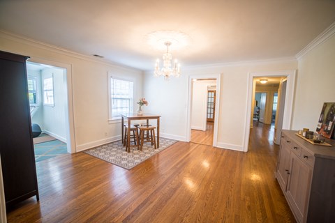 a living room and dining room with a table and a chandelier