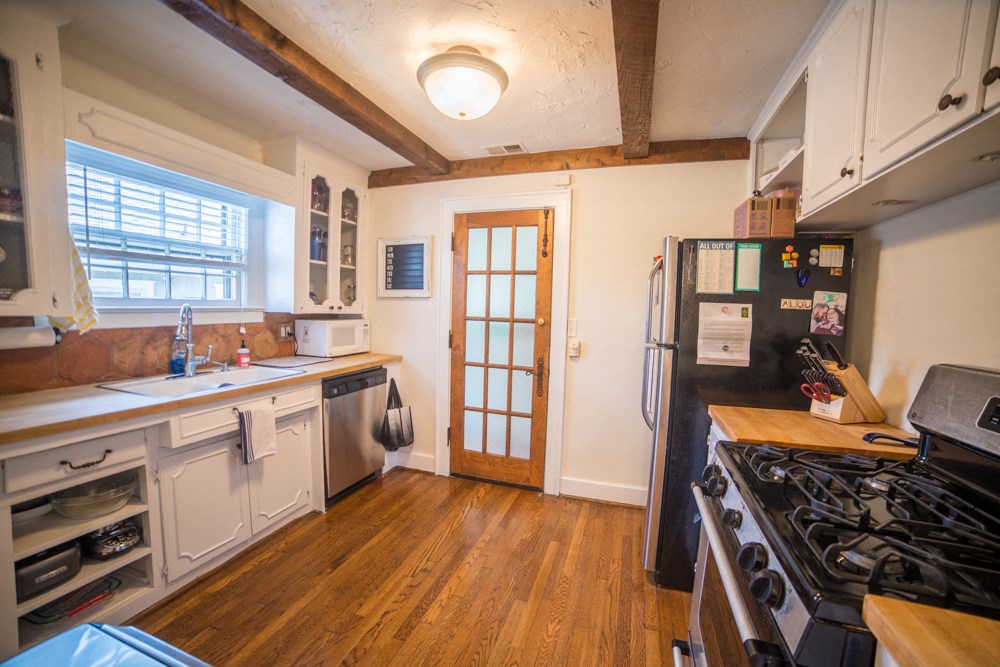 a kitchen with white cabinets and a stove and a refrigerator