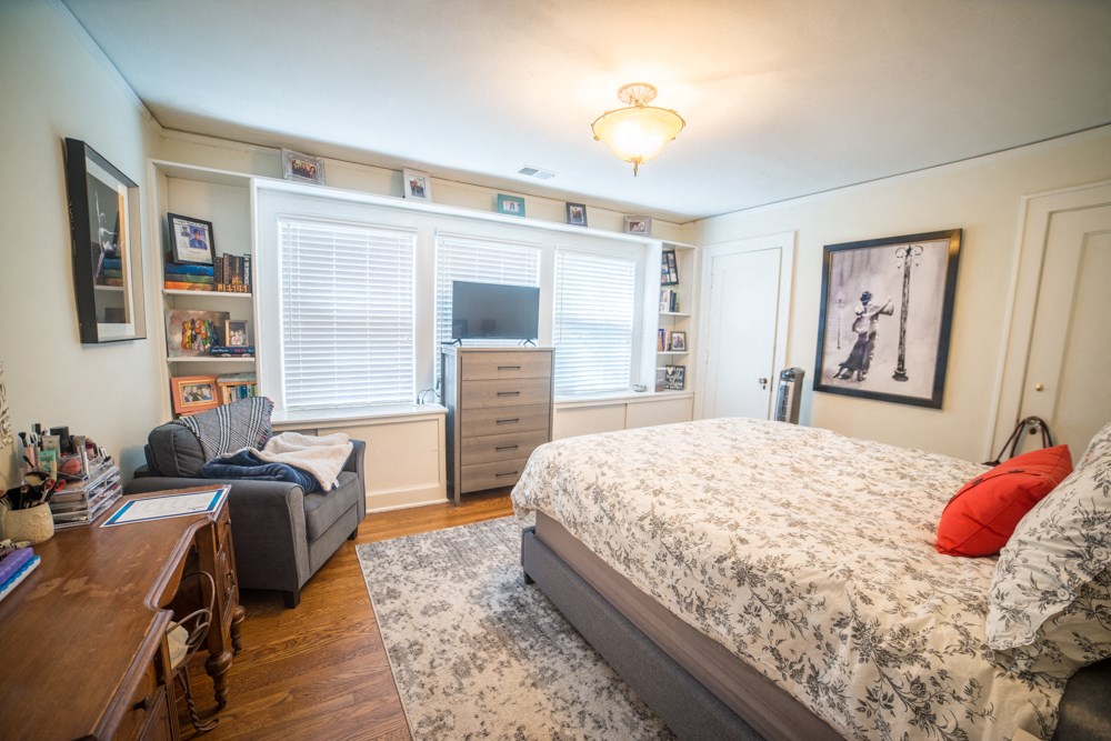 a bedroom with a bed and a couch and a tv