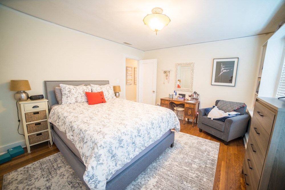 a bedroom with a bed and a chair and a desk