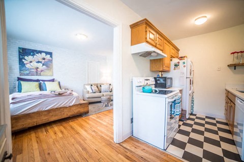 a kitchen with a stove refrigerator and a bed