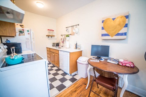 a kitchen with a wooden table and a heart painting on the wall