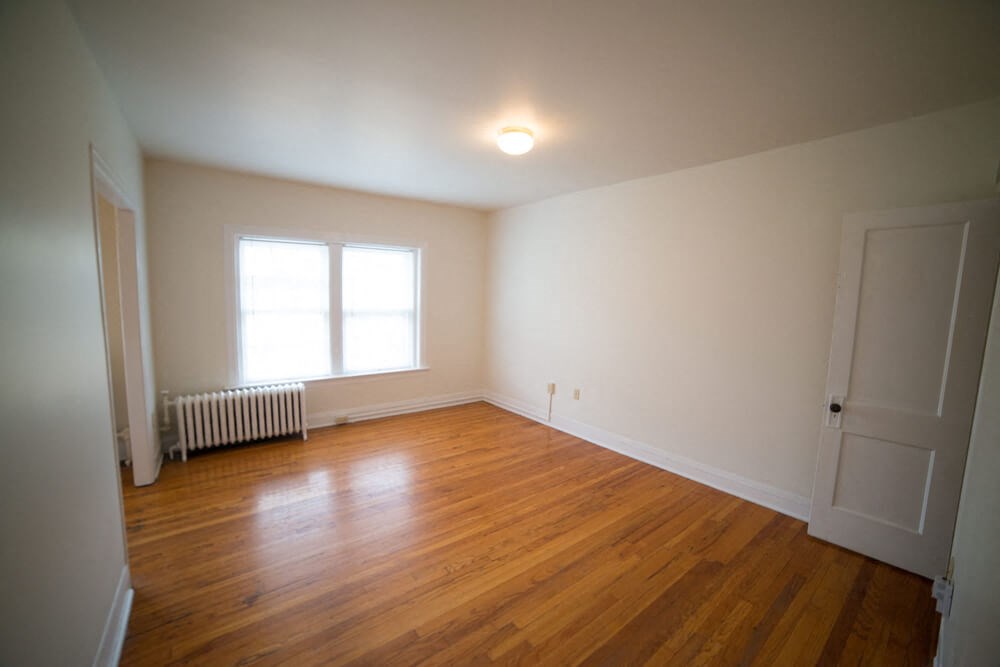 the living room of an empty house with a wooden floor