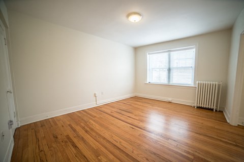 the living room of an empty house with wooden floors and a window
