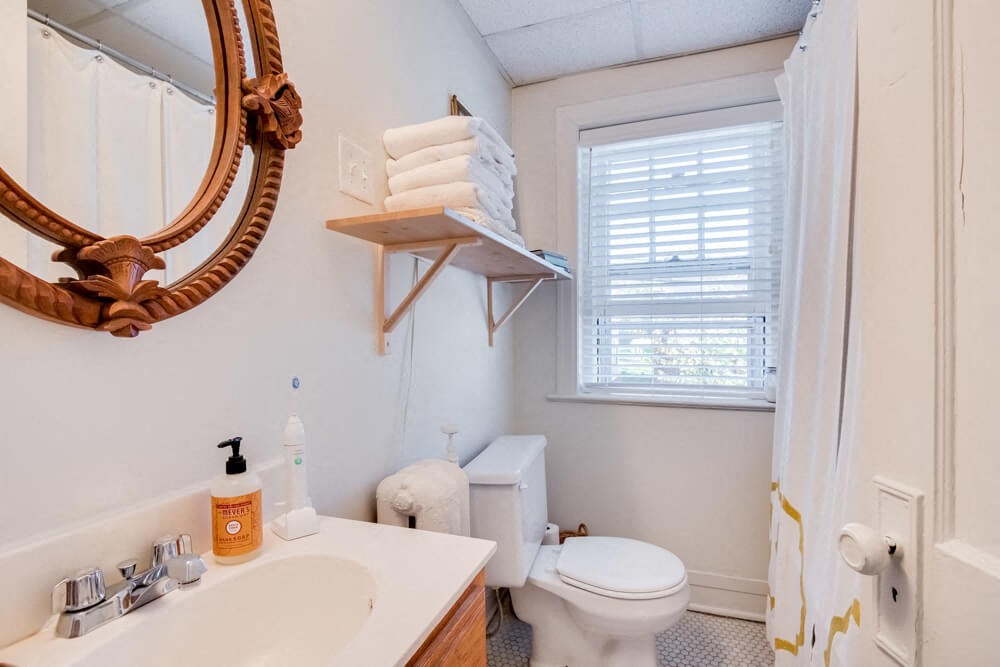 a bathroom with a sink toilet and a mirror