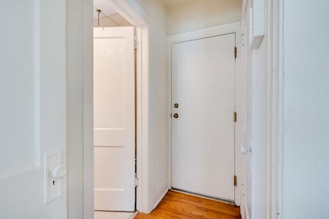 a bedroom with two doors and a wood floor