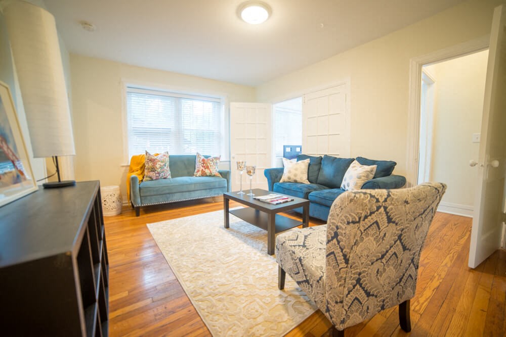 a living room with couches and chairs and a tv