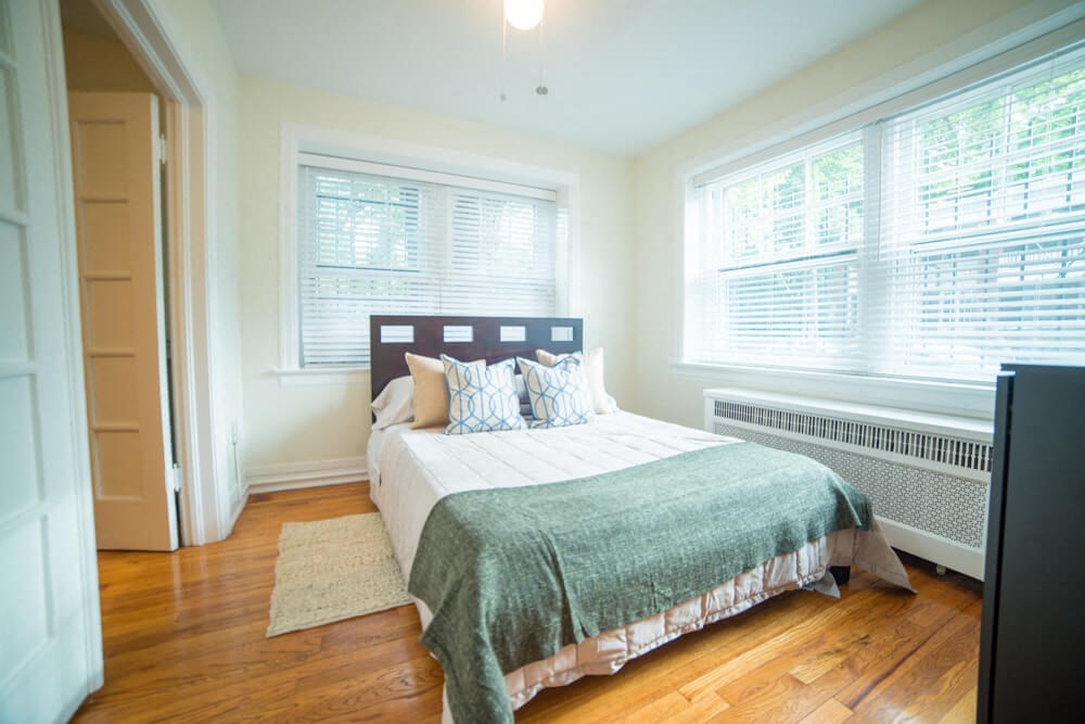a bedroom with a bed and two windows